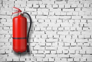 fire extinguisher on white brick wall